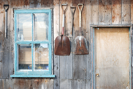 two shovels hanged near windows thumbnail