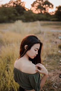 women wearing off-shoulder top touching right shoulder with right hand thumbnail