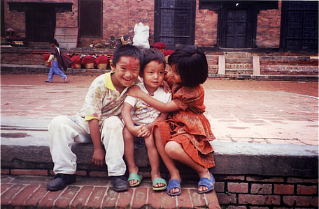 Two kids hugging a smaller kid in Kathmandu, Nepal thumbnail
