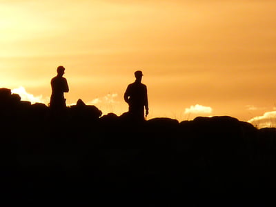 silhouette of two people on top of hill thumbnail