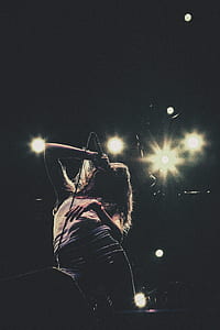 woman singing under lights low angle photography thumbnail