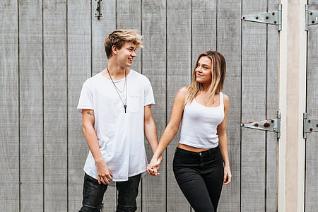man and woman holding hands together while staring each other thumbnail