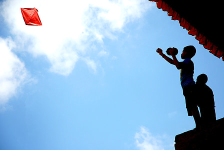 silhouette photography of two children playing kite thumbnail