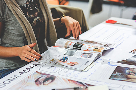 woman sitting about to turn page on catalog thumbnail