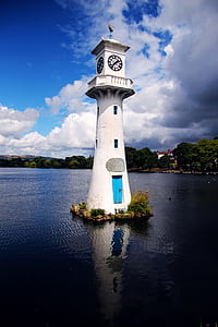 white concrete lighthouse on body of water thumbnail