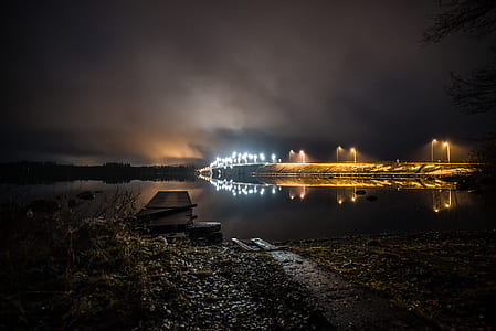Walls With Lights Near Calm Body of Water at Night Time thumbnail