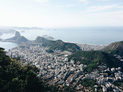 high angle photography of a city surrounded by mountains thumbnail
