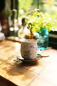 round white teacup on saucer on table thumbnail