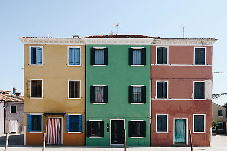 beige, green, and red concrete buildings thumbnail