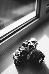 Grayscale Photo of Classical Camera Near Window thumbnail