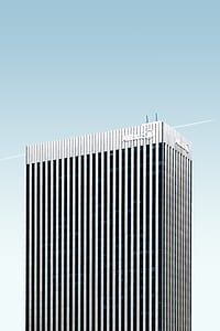 gray high-rise concrete building on white and blue sky thumbnail