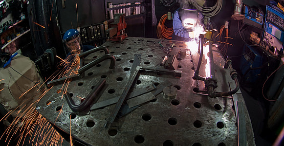 man welding black metal frame thumbnail