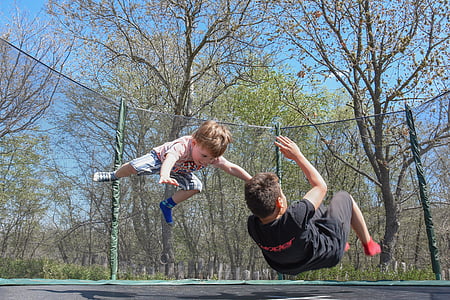 two children playing on a trampoline thumbnail