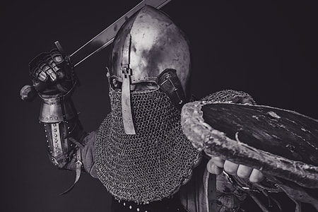 person holding sword in grayscale photography thumbnail