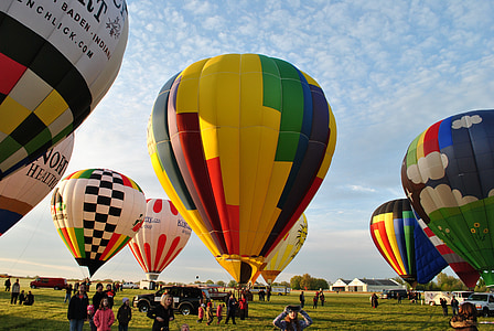 people standing in open field with hot air balloons thumbnail