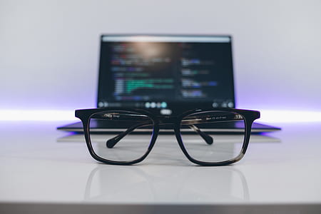 black framed eyeglasses in front of laptop inside table thumbnail