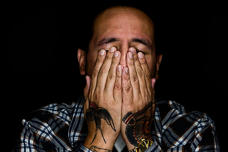 man wearing plaid holding face thumbnail