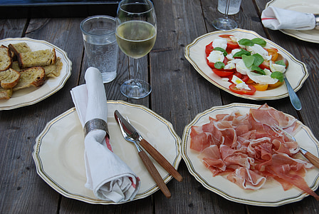 cooked ham beside tomato salad and wine glass thumbnail