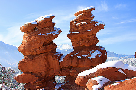 snow-covered brown boulder under blue sky thumbnail
