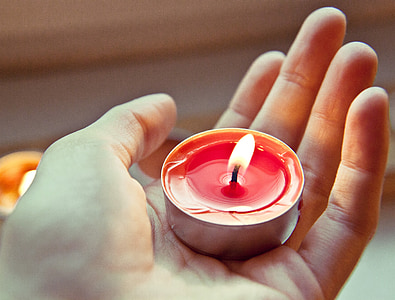 person holding red tealight candle thumbnail