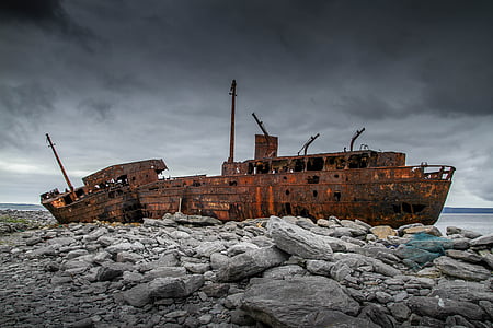 brown ship wreck on rocky shore thumbnail
