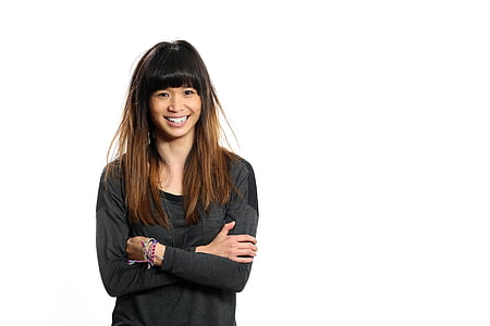 woman wearing gray and black scoop-neck long-sleeved shirt standing inside well lighted room thumbnail