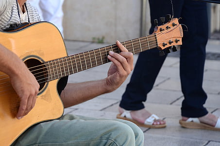 shallow focus photography of man using brown cutaway acoustic guitar thumbnail