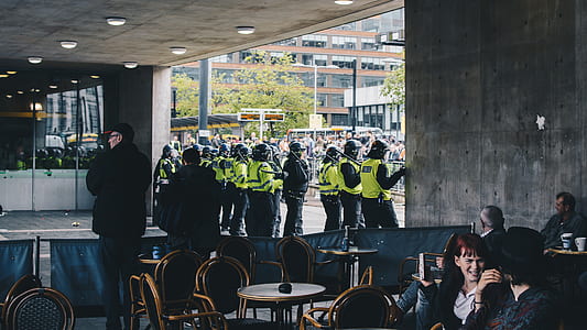men in green vests standing under roof thumbnail