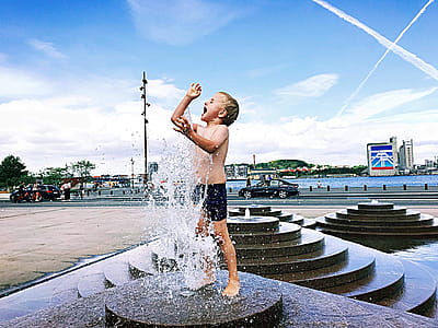 Boy Standing On Outdoor Fountain thumbnail