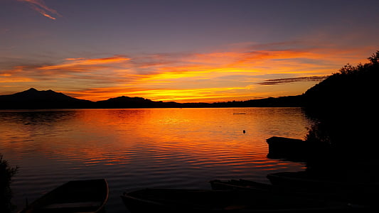 silhouette of boat on river during golden hour thumbnail