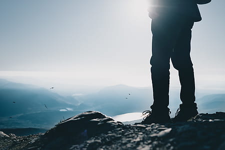 person standing on rocks overlooking mountain range thumbnail