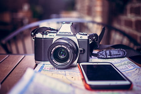 Olympus camera beside a phone on table thumbnail