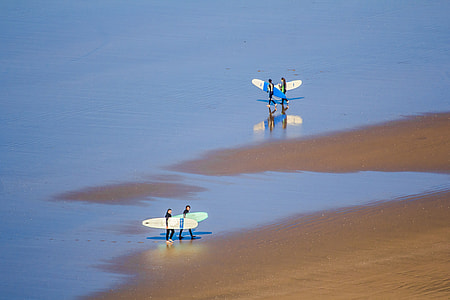 four surfers on seashore thumbnail