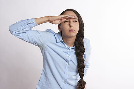 man wearing blue dress shirt standing near wall thumbnail