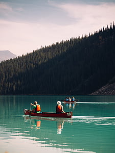 brown kayak boat on blue ocean water under gray sky thumbnail