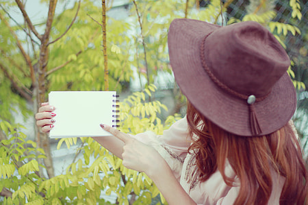 human holding white spiral notebook during daytime thumbnail