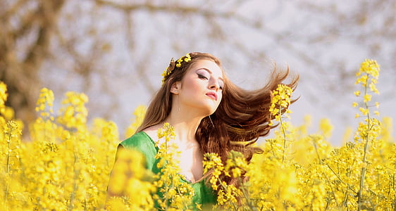 selective focus photography of woman wearing headpiece in field of yellow petaled flower thumbnail