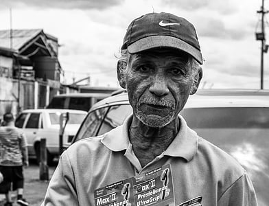 grayscale photo of man wearing Nike fitted cap at daytime thumbnail