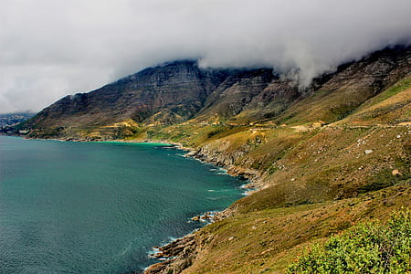 blue ocean beside brown mountain during daytime thumbnail