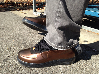 man wearing pair of brown Nike shoes on concrete floor thumbnail