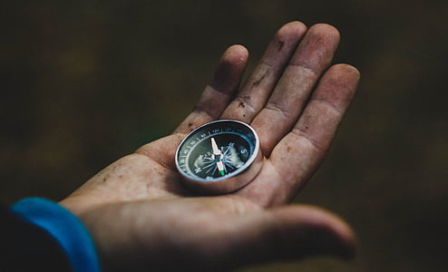 person holding black compass thumbnail