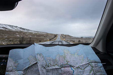 person taking photo of blue and multicolored map in front of concrete road thumbnail