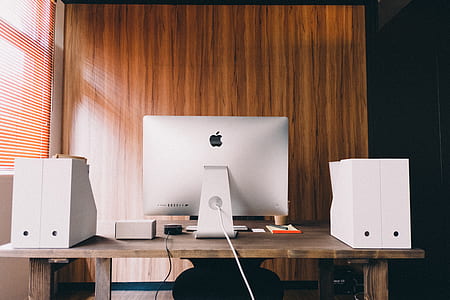 silver iMac on brown wooden desk thumbnail