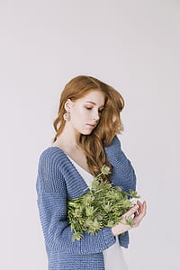 Woman in Blue Cardigan Holding Green Flowers thumbnail