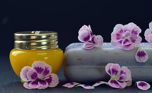 selective focus photography of yellow jar and purple petals thumbnail