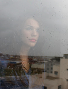 woman wearing blue button-up shirt through glass windows thumbnail