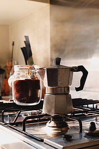silver moka pot on black gas range cook top thumbnail
