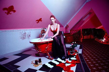 woman in red spaghetti strap top sitting on red ceramic bath=tub thumbnail
