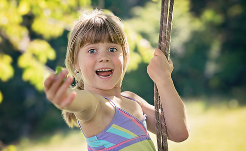 close up photo of girl in purple and green spaghetti strap dress holding rope thumbnail