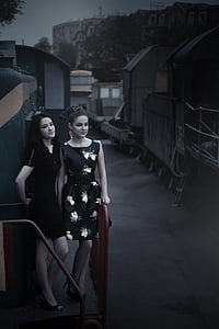 two woman standing on sidewalk thumbnail